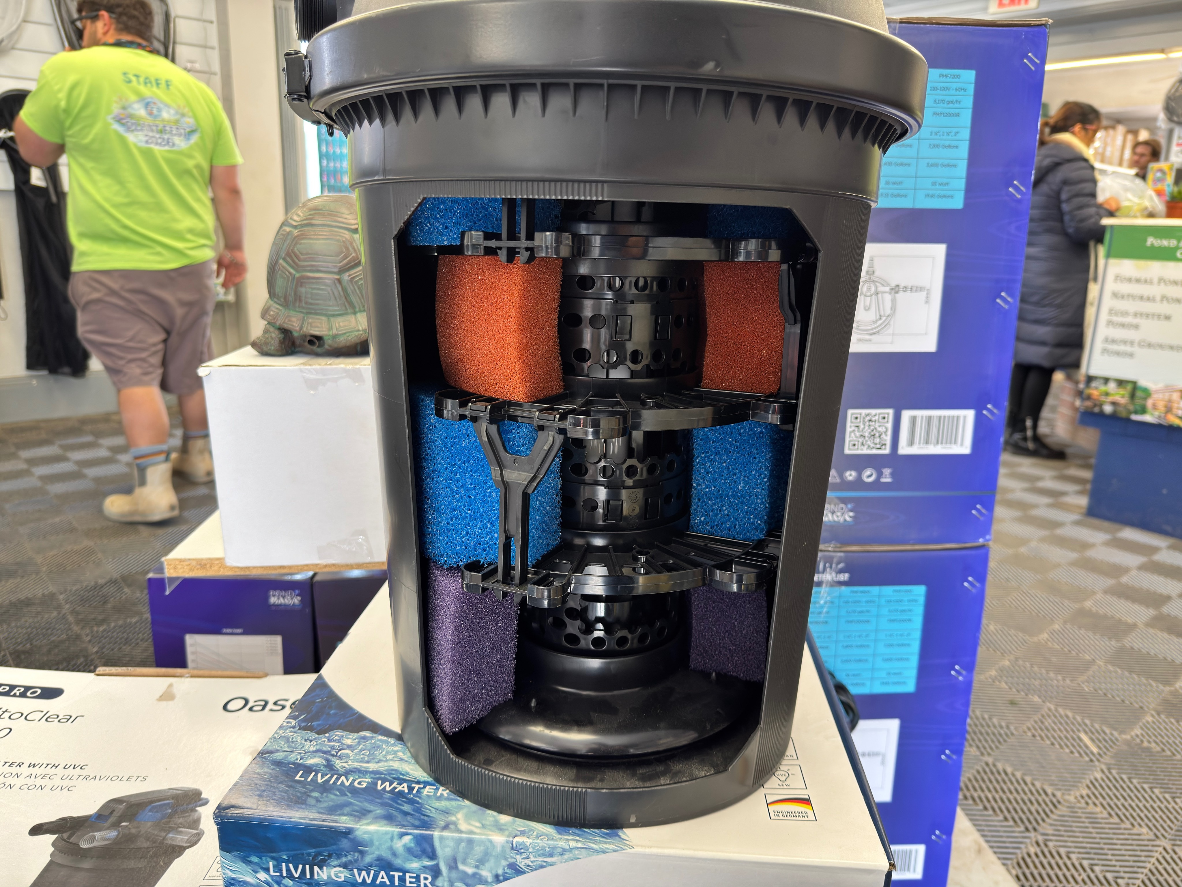 Cutaway pond filtration system display with layered media at Plant Fest 2026
